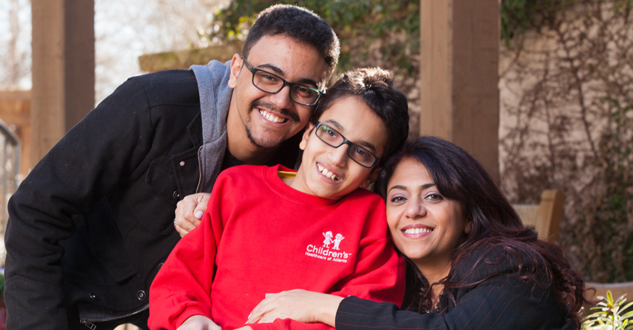 Teen robotic rehabilitation patient smiling with family