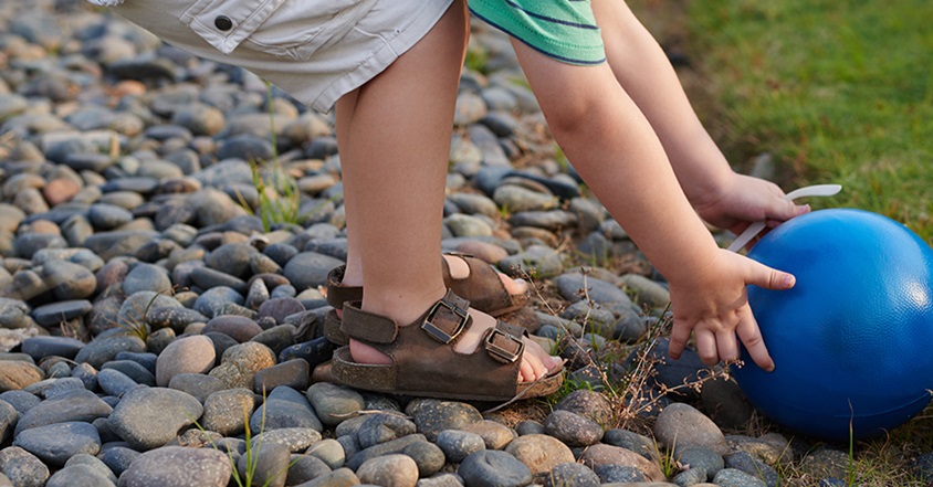 Toddler boy reaching for ball