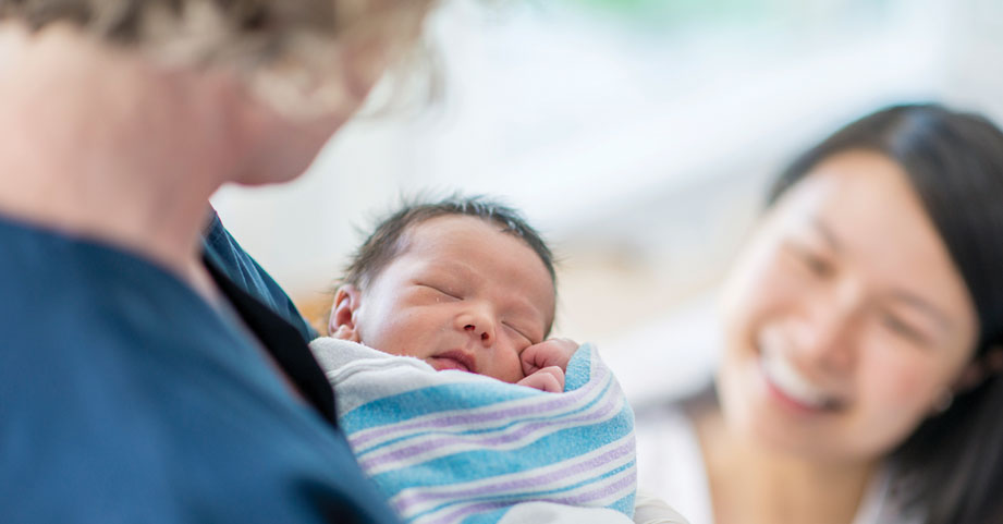 A newborn with doctor and mom
